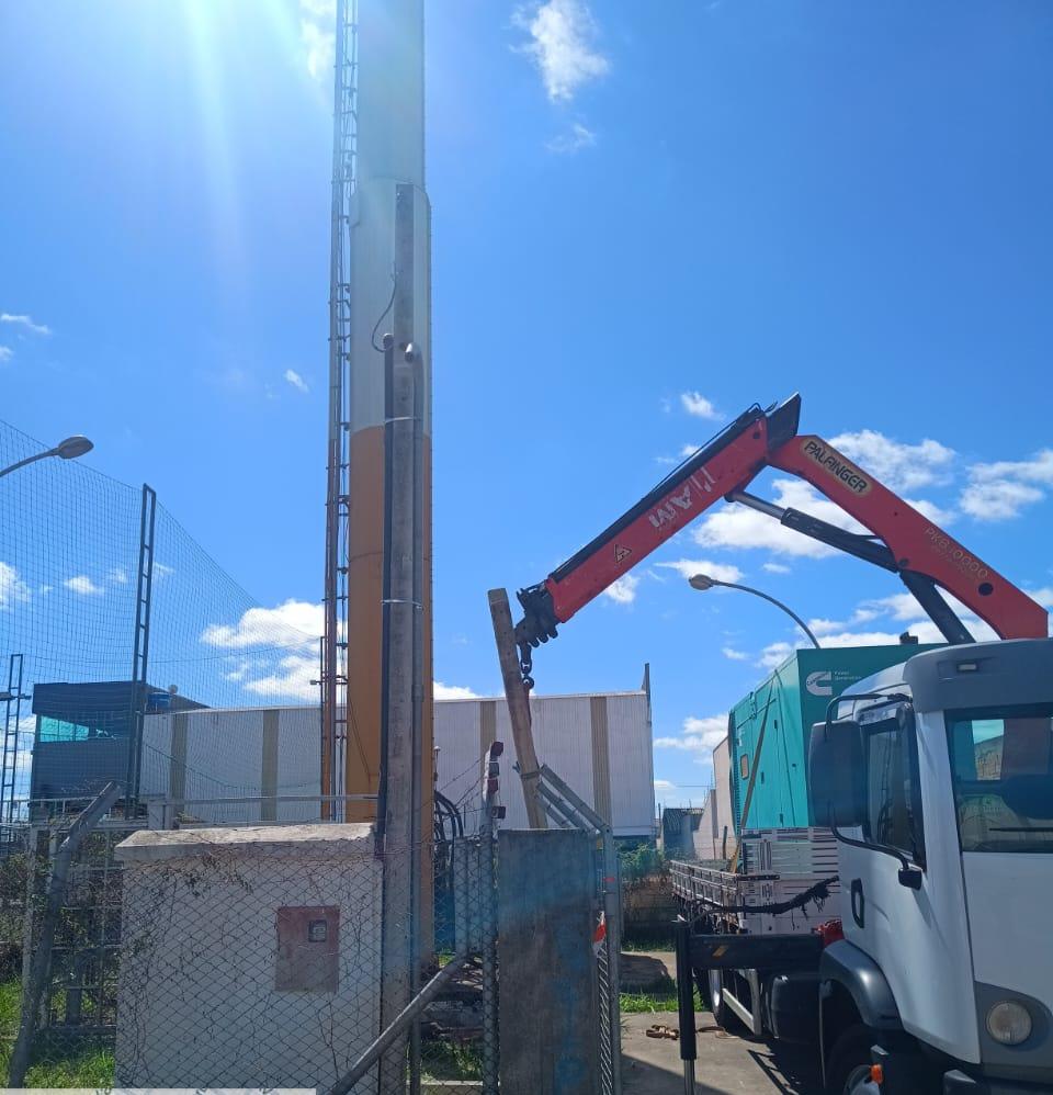 Caminhão Munck da FLG Geradores em operação, com gerador ao fundo, em Curitiba
